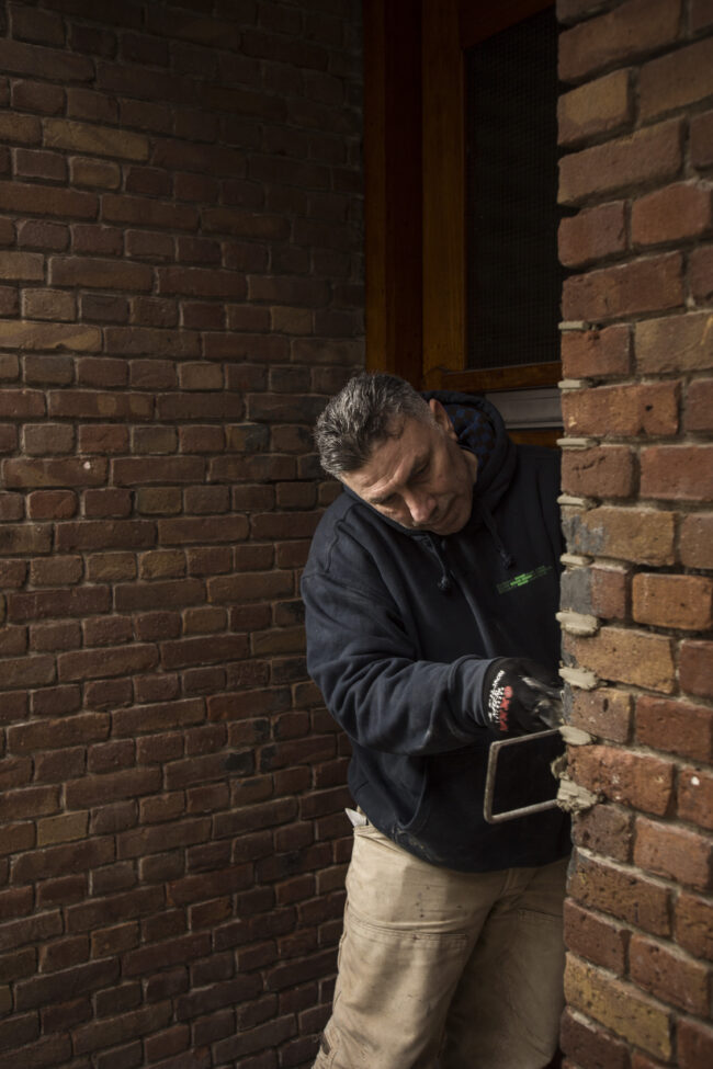 Metselaar Hseyin van Marc Bohle bij het pand hoek Marco Polostraat Jan Evertsenstraat in Amsterdam.